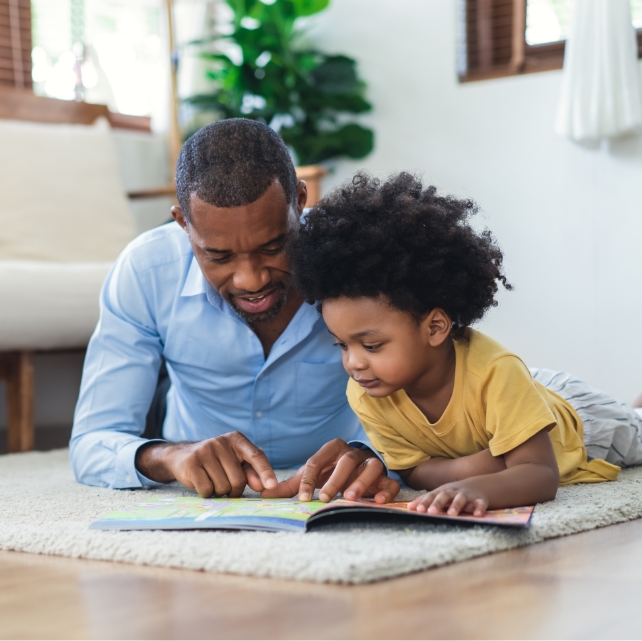 dad reading a book to his child abotu the first visit to the dentist