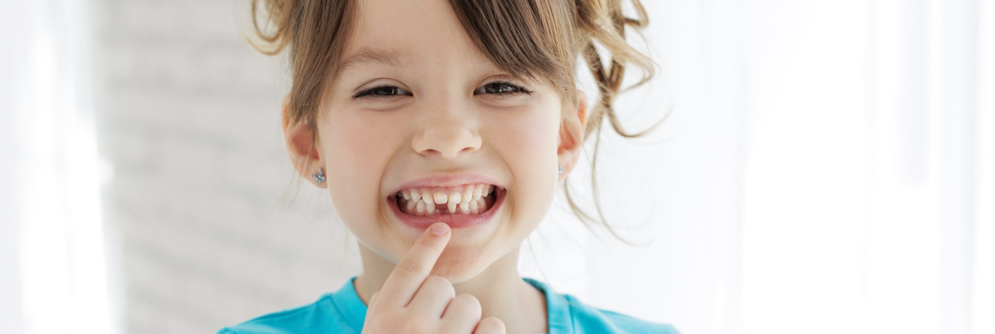 image of a child showing is teeth at the dental clinic alain cyr in boucherville