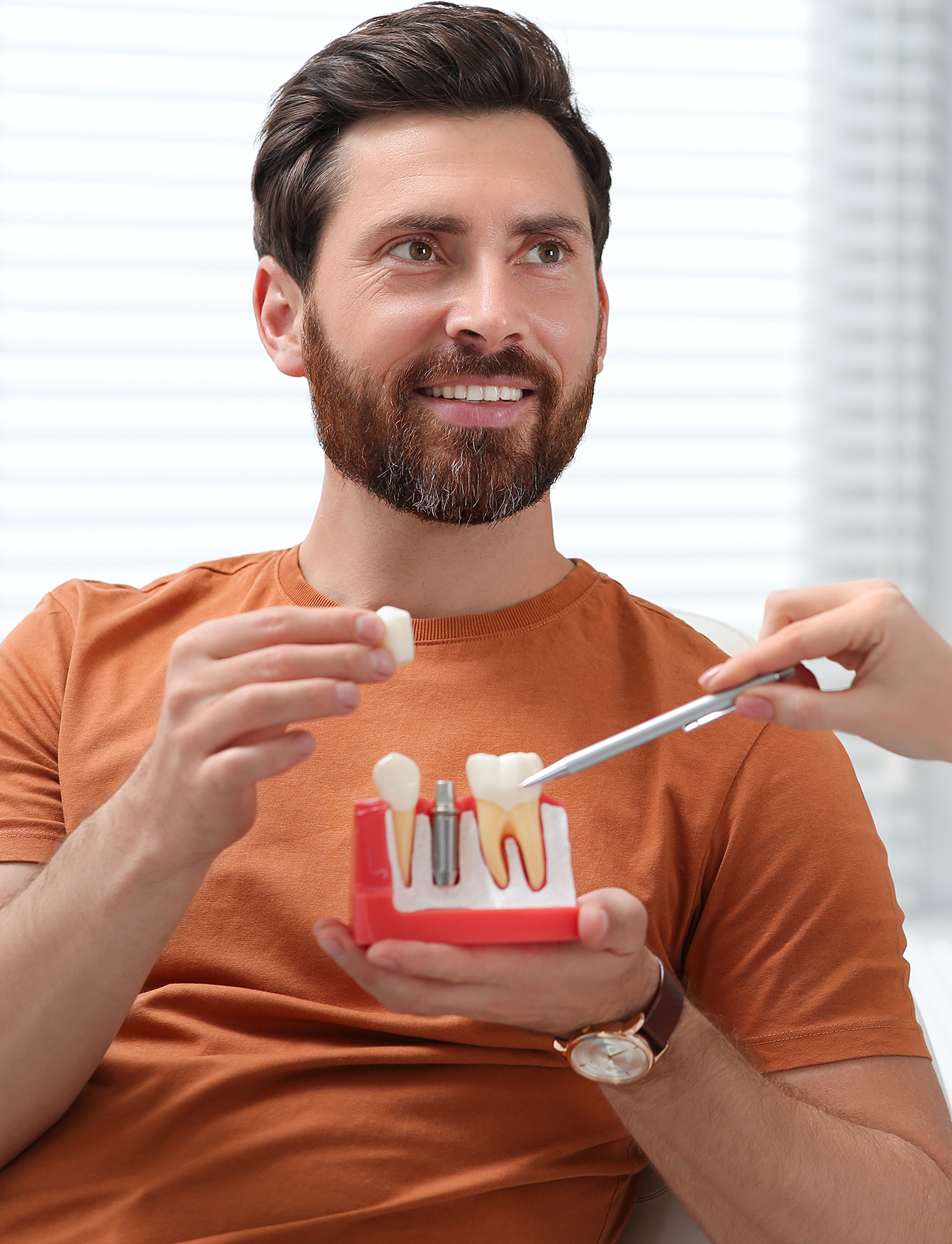 a male patient learning about modern implant at the dental clinic