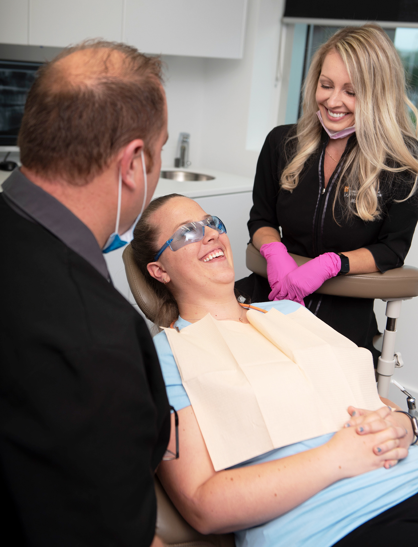 a female patient in a dental chair with Alain Cyr and a hygienist at the dental clinic